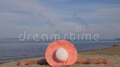 美丽的女人躺在海滩上做热身腿。